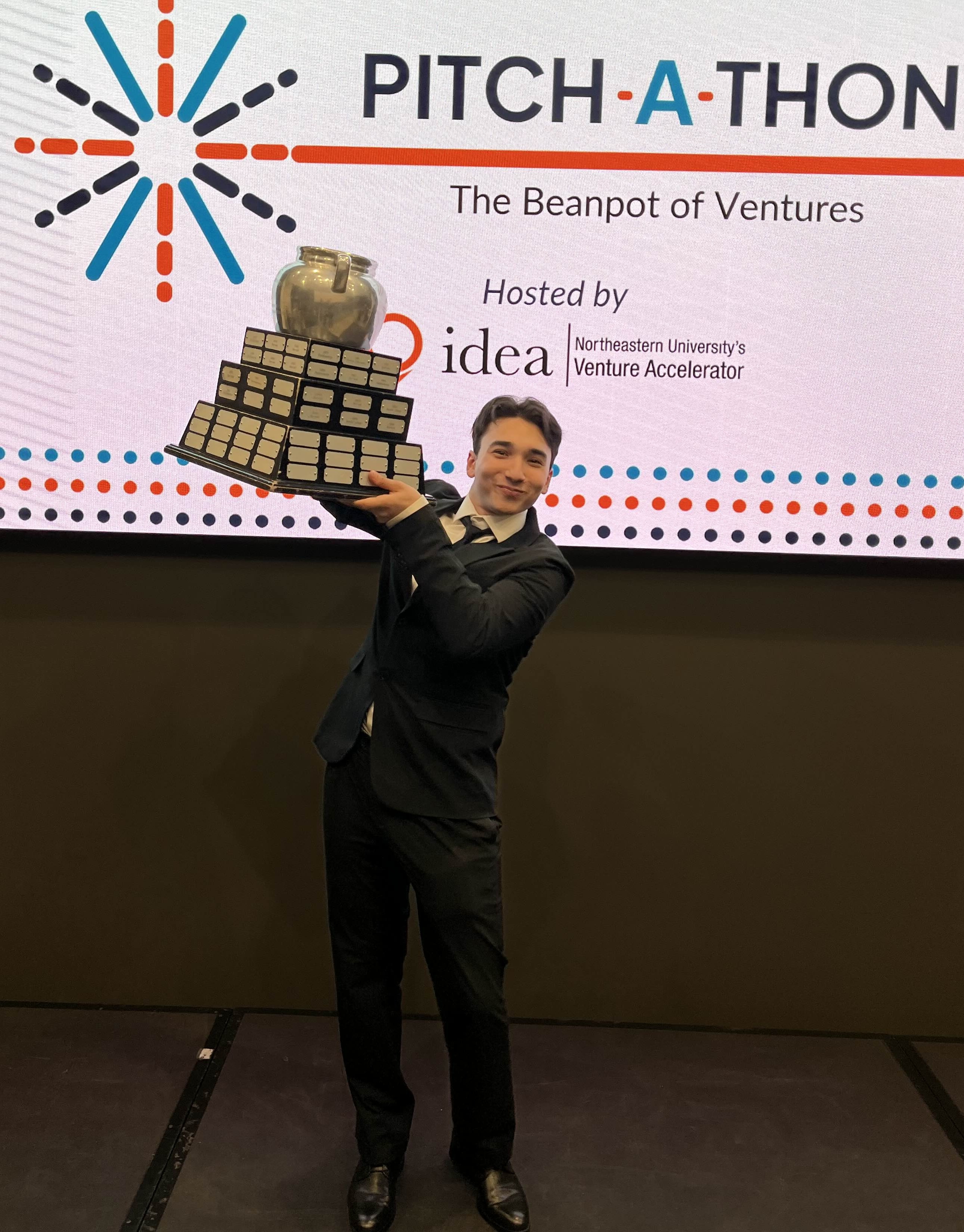 Me holding the beanpot trophy at Pitchathon 2025